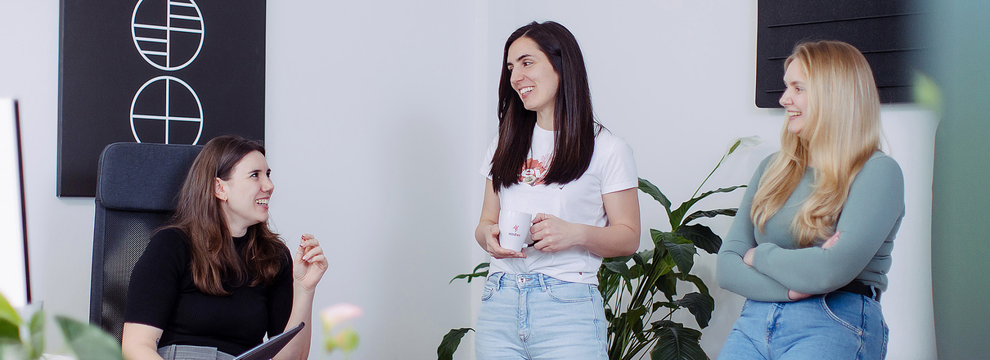 Drei Kolleginnen im Teamgespr&auml;ch in modernem B&uuml;ro