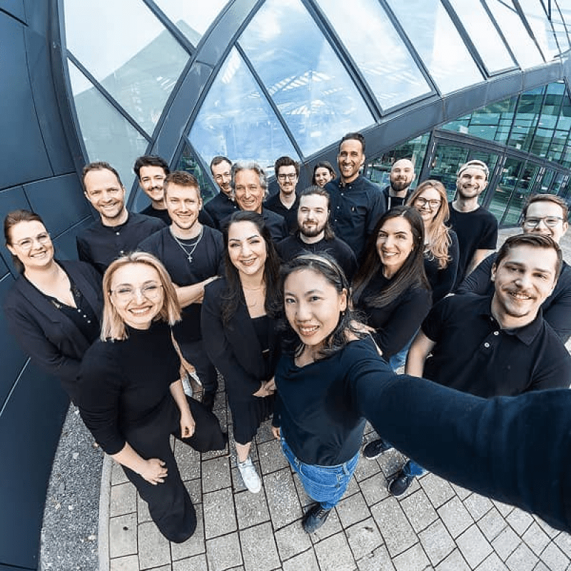 Gruppenfoto des mindtwo Teams im Freien, aufgenommen mit Fisheye-Perspektive